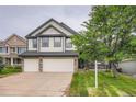 Traditional two-story home with three-car garage, stone accents, and a well-manicured lawn at 22367 Quail Run Dr, Parker, CO 80138
