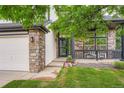 Charming front porch with stone accents, black railing, and beautiful landscaping at 22367 Quail Run Dr, Parker, CO 80138