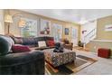 Comfortable living room with a plush sectional, patterned ottoman, and natural light from the windows at 2574 E Geddes Ave, Centennial, CO 80122