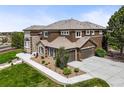 Aerial view of the home showing the three car garage, extensive landscaping, and beautiful exterior finishes at 8518 High Ridge, Castle Pines, CO 80108