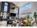 Elegant living room with a fireplace, soaring ceilings, large windows and a comfortable leather sofa at 3564 Doubletrack Ln, Castle Rock, CO 80108