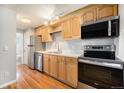 Modern kitchen with stainless steel appliances, wooden cabinets and ample counter space at 155 S Pennsylvania St # 308, Denver, CO 80209
