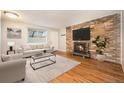 Cozy living room with a brick fireplace, hardwood floors and a comfortable seating arrangement at 155 S Pennsylvania St # 308, Denver, CO 80209