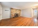 Inviting living room featuring hardwood floors and a brick fireplace, perfect for relaxation and gatherings at 155 S Pennsylvania St # 308, Denver, CO 80209