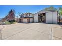 Two-story home with a large driveway and detached garage/storage at 8167 S Dover St, Littleton, CO 80128