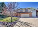 Two-story home showcasing the double door entryway, attached garage, and a spacious driveway at 8167 S Dover St, Littleton, CO 80128