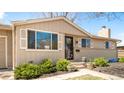 Ranch style home with a beautiful front yard, manicured shrubbery and steps to a black front door at 2756 E Euclid Ave, Centennial, CO 80121