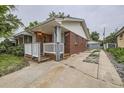 Side view of a cozy brick home with a white picket fence and detached garage at 1824 S Columbine St, Denver, CO 80210