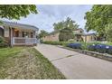 Charming home with a well-maintained lawn and colorful flower beds along the driveway at 1824 S Columbine St, Denver, CO 80210