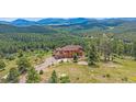 A beautiful two-story home with a large driveway and lush greenery surrounding the property at 31231 Red Hawk Trl, Conifer, CO 80433