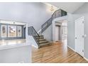 Elegant foyer featuring hardwood floors, a staircase with iron railings, and ample natural light at 5789 S Jay St, Littleton, CO 80123