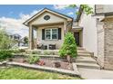 Inviting front porch with seating area, complemented by a well-maintained garden and attractive home facade at 5789 S Jay St, Littleton, CO 80123