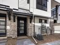 Inviting townhome entrance with stone veneer and a stylish black front door at 2036 S Holly St # 4, Denver, CO 80222