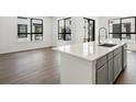 Bright open concept kitchen with island, stainless steel appliances, and wood floors at 2036 S Holly St # 4, Denver, CO 80222