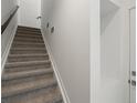 Carpeted staircase featuring a modern handrail and bright, neutral walls at 2036 S Holly St # 4, Denver, CO 80222