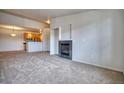Cozy living room with fireplace open to kitchen featuring stainless steel appliances at 2875 Blue Sky Cir # 4-303, Erie, CO 80516