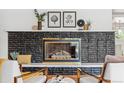 Close up of living room fireplace with black brick, decor, and furniture in view at 2180 Myrtlewood Ln, Lakewood, CO 80215