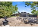 Home with a large driveway, mature trees, and a well-maintained front yard at 2180 Myrtlewood Ln, Lakewood, CO 80215