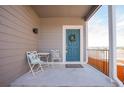 Close up of the front porch with a table and two chairs beside the blue front door with a wreath at 1677 Valley Oak Ct, Castle Rock, CO 80104
