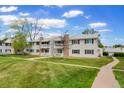 Well-maintained exterior view of multi-unit buildings, showcasing lush green lawns and sidewalks on a sunny day at 14444 E Colorado Dr # 204, Aurora, CO 80012