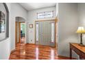 Elegant foyer with hardwood floors, stylish front door, and decorative window above at 6475 Umber Cir, Arvada, CO 80007