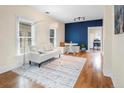 Open living room with hardwood floors, white couch, and a blue accent wall at 2537 Chase St, Edgewater, CO 80214