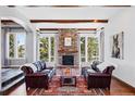 Cozy living room with stone fireplace, wood beams, and large windows with mountain views at 290 Skyhill Dr, Evergreen, CO 80439