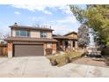 Spacious home with a wide driveway, well-kept lawn, and attractive exterior design elements at 7551 S Garland St, Littleton, CO 80128