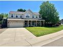 Beautiful two-story home boasts manicured lawn, mature trees, and a spacious driveway at 10512 Cimarron St, Longmont, CO 80504