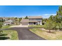 Two-story home with large front lawn, covered porch, and a driveway with a basketball hoop at 6871 S Himalaya Way, Centennial, CO 80016
