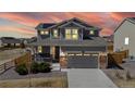 Charming two-story home bathed in a warm sunset glow featuring solar panels and a two-car garage at 13485 Niagara St, Thornton, CO 80602