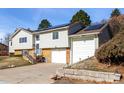 Two-story home with gray siding, brick accents, an attached garage, and solar panels in a residential neighborhood at 717 Anderson St, Castle Rock, CO 80104