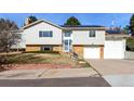 Charming two-story home with light gray siding, brick accents, a well-manicured yard, and solar panels on the roof at 717 Anderson St, Castle Rock, CO 80104