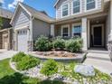 Landscaped front garden featuring decorative rocks, shrubs, and flowers at 14565 Vancouver Pl, Parker, CO 80134