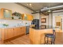 Modern kitchen with wood cabinets, granite countertops, and island at 1499 Blake St # 4O, Denver, CO 80202