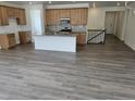 Open-concept kitchen features a central island, wooden cabinets, and stainless steel appliances at 17156 W 92Nd Loop, Arvada, CO 80007