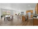 Bright, open-concept living space with hardwood floors, and adjacent kitchen and dining areas at 17156 W 92Nd Loop, Arvada, CO 80007