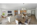 Open-concept living area with hardwood floors, modern lighting, and access to kitchen at 17156 W 92Nd Loop, Arvada, CO 80007