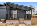 Covered porch with wood decking provides a cozy entrance to the home at 5523 Tejon St, Denver, CO 80221