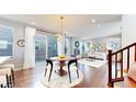 Open concept dining room with modern light fixture and access to the outdoor patio space at 7932 E 49Th Pl, Denver, CO 80238