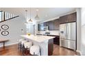 Modern kitchen with stainless steel appliances, island with seating, and dark wood cabinets at 7932 E 49Th Pl, Denver, CO 80238