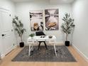 Home office features a white desk, neutral rug, decor, and large art prints on the wall at 7932 E 49Th Pl, Denver, CO 80238
