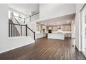 Open-concept living space with staircase and kitchen, featuring hardwood floors and modern finishes at 2464 Wesley Ln, Lafayette, CO 80026