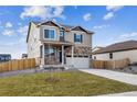 Beautiful two-story home featuring a stone facade, a two-car garage and a landscaped front yard at 27404 E Byers Ave, Aurora, CO 80018