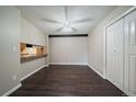 Dining area featuring hardwood floors, ceiling fan, and adjacent breakfast bar at 12143 Melody Dr # 103, Denver, CO 80234