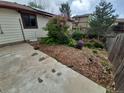 Side yard with mulched garden, flowering bushes, and a concrete area for outdoor enjoyment at 2758 S Salida St, Aurora, CO 80013