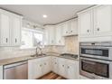 Updated kitchen with stainless steel appliances, granite counters and classic white cabinets at 1350 Valentia St, Denver, CO 80220