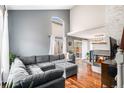 Bright living room with hardwood floors, a fireplace, and a large sofa, perfect for entertaining at 1271 Braewood Ave, Highlands Ranch, CO 80129