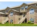 Inviting exterior of a multi-story condo building featuring stone accents, stairs, and manicured lawn at 3261 S Waco Ct # K, Aurora, CO 80013