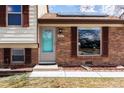 Welcoming front entrance with a vibrant teal door and updated brickwork, adding a touch of modern charm at 9510 Flower St, Broomfield, CO 80021